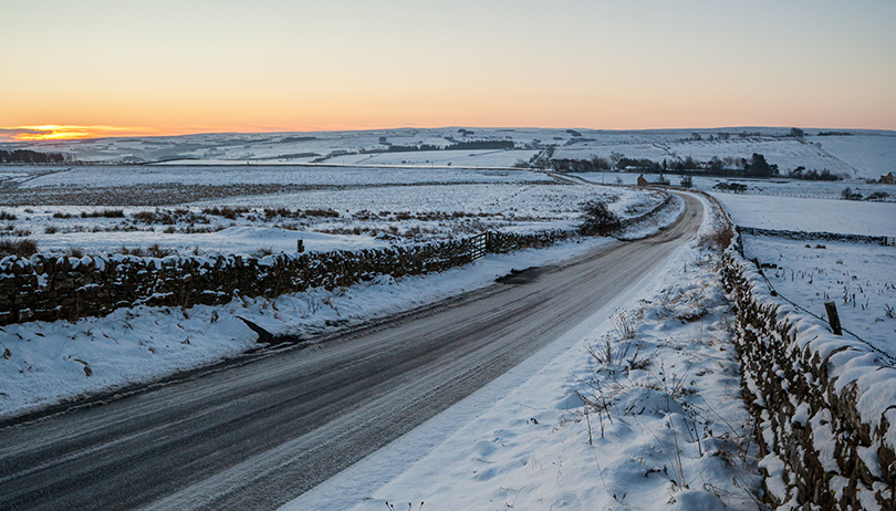 icy road in winter at sunrise tinified